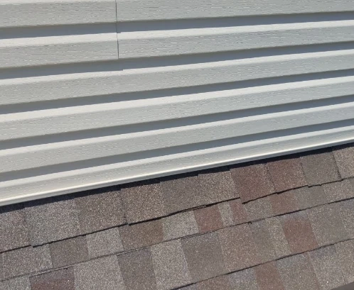 White vinyl siding and asphalt shingles.